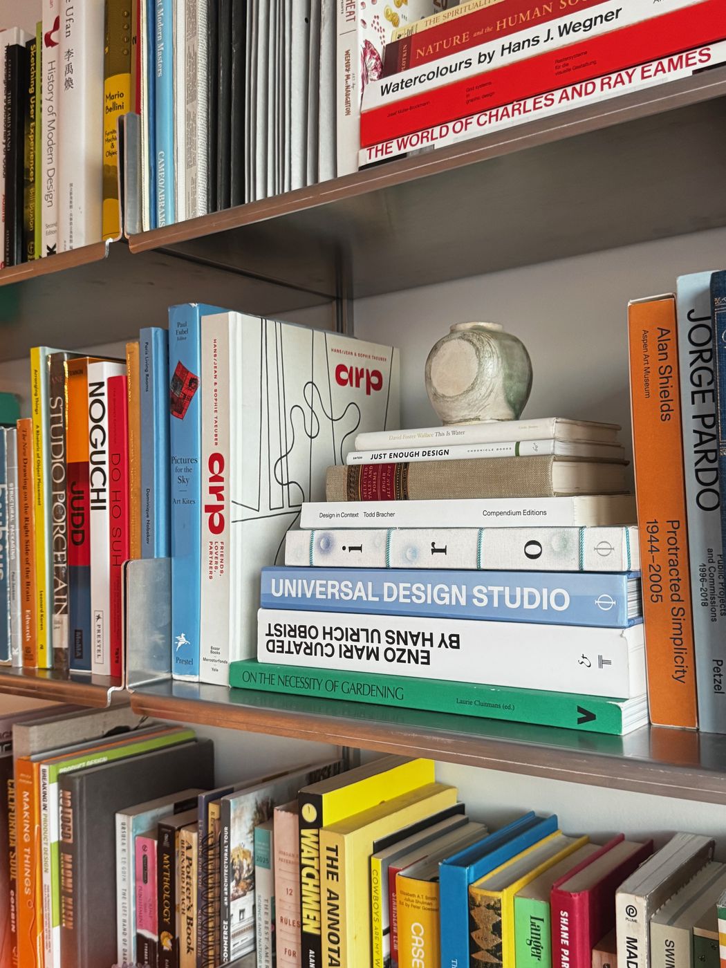 Stacked books and objects on aluminum shelves